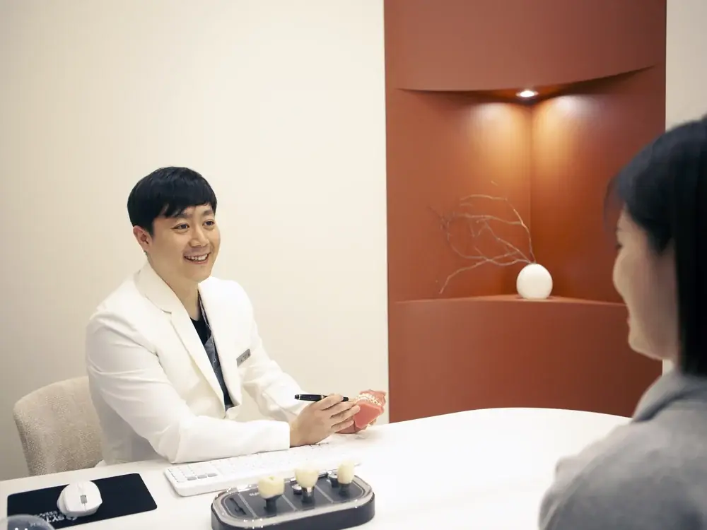 상담실에서 환자와 마주 앉아 이야기하는 원장