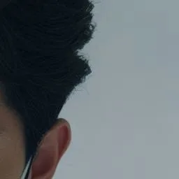 수술등 아래 마스크를 착용한 치과 의사의 귀와 머리카락 일부
