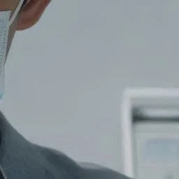마스크를 착용한 치과 의사의 얼굴 옆모습과 진료실 배경