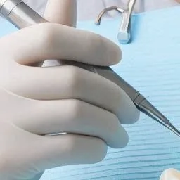 장갑을 낀 손으로 치과용 기구를 잡고 있는 모습
