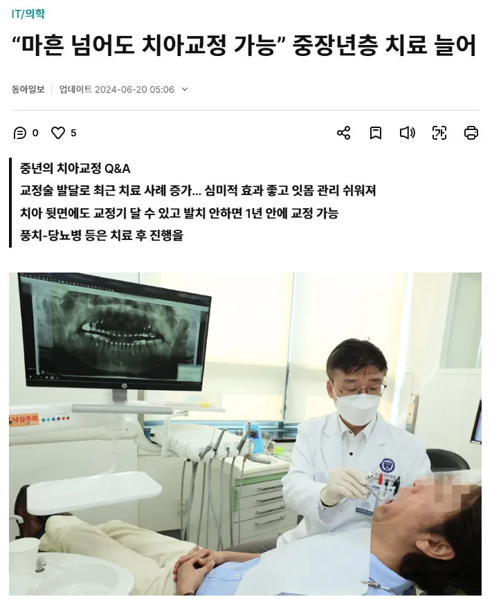 치과 진료실에서 의사가 환자의 치아를 검진하는 모습. 배경에는 파노라마 엑스레이 사진이 보이는 모니터가 있다.