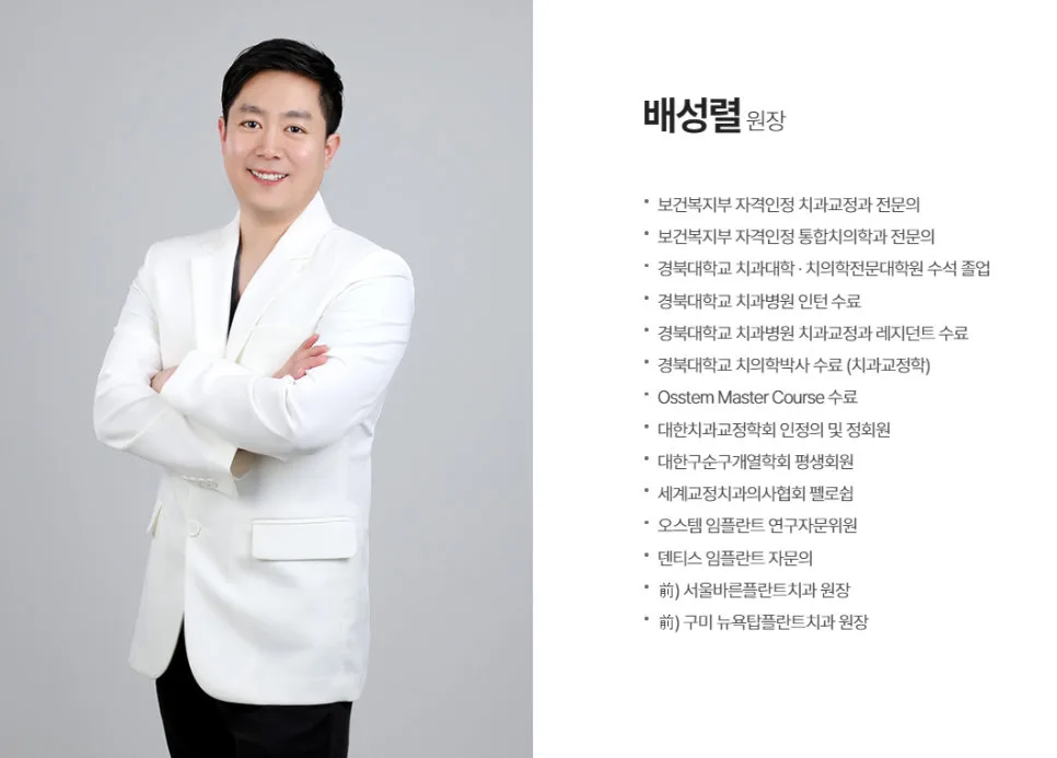 하얀색 재킷을 입고 팔짱을 낀 채 정면을 보고 웃고 있는 남성 치과 의사